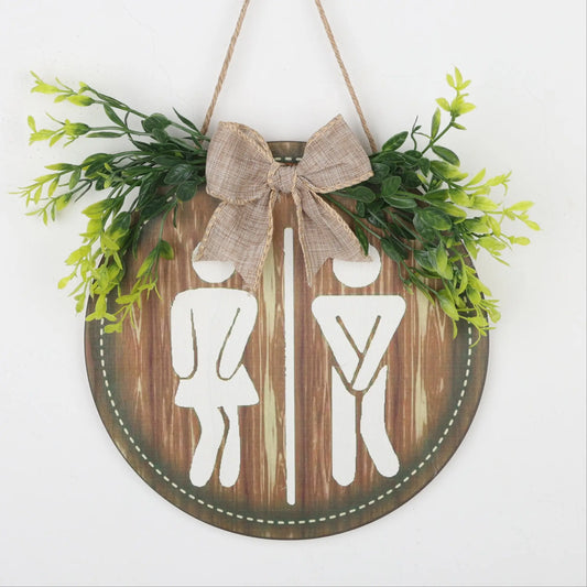 Round Wooden Restroom Sign With Greenery and Bow